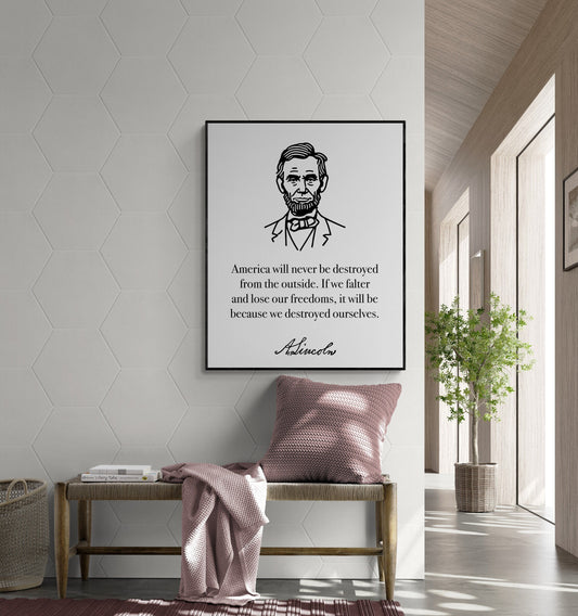 May include: A black and white illustration of Abraham Lincoln with a quote that reads &#39;America will never be destroyed from the outside. If we falter and lose our freedoms, it will be because we destroyed ourselves. - A. Lincoln.&#39; The illustration is framed and hanging on a white wall in a room with a wooden bench, a pink throw blanket, and a potted plant.