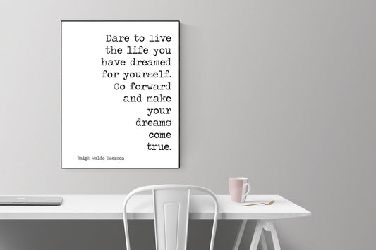 May include: A black and white typography print with the quote &#39;Dare to live the life you have dreamed for yourself. Go forward and make your dreams come true.&#39; by Ralph Waldo Emerson. The print is framed and hanging on a white wall above a white desk with a white chair and a pink mug.