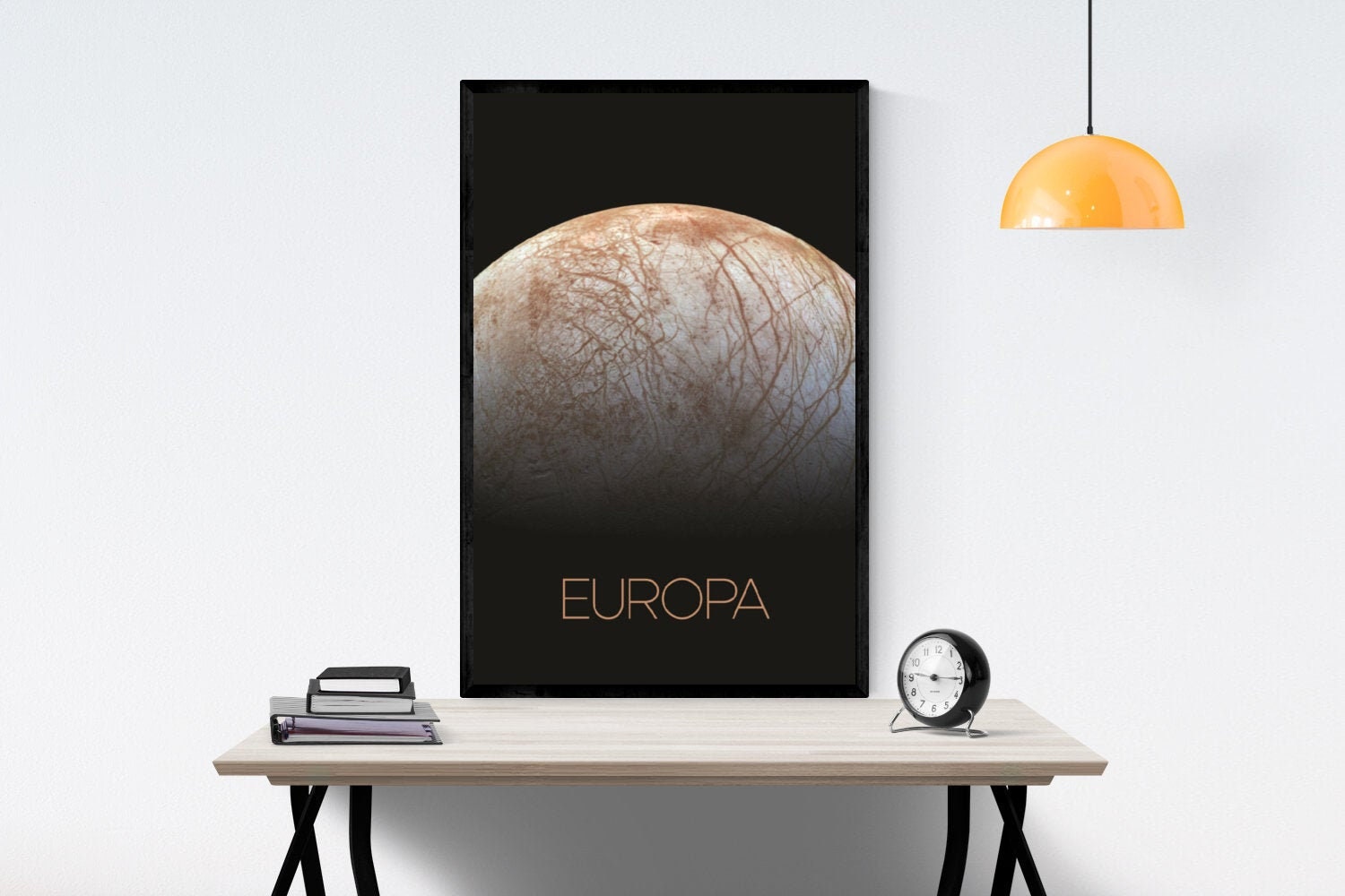 May include: A black and white poster with a close-up image of Europa, one of Jupiter&#39;s moons. The moon is a light brown color with a dark brown, cracked surface. The word &#39;EUROPA&#39; is written in gold lettering at the bottom of the poster.