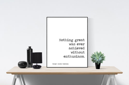 May include: A black and white typography print with the quote 'Nothing great was ever achieved without enthusiasm.' The quote is attributed to Ralph Waldo Emerson. The print is framed and displayed on a wooden table with a black lamp, a black bottle, and a potted succulent plant.