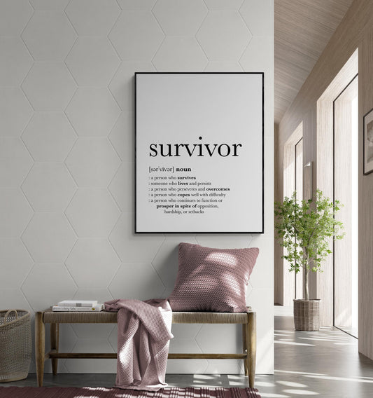 May include: A black and white typography print with the word 'survivor' in bold text. The definition of the word is listed below, including the pronunciation, part of speech, and multiple definitions. The print is hanging on a white wall with a hexagonal pattern.