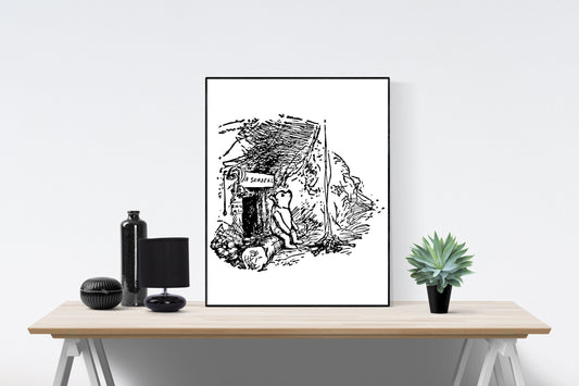 May include: A black and white illustration of a bear sitting outside a small house with a sign that reads 'The Sandbox'. The illustration is framed and displayed on a wooden table with a black bottle, a black lamp, and a green succulent plant.