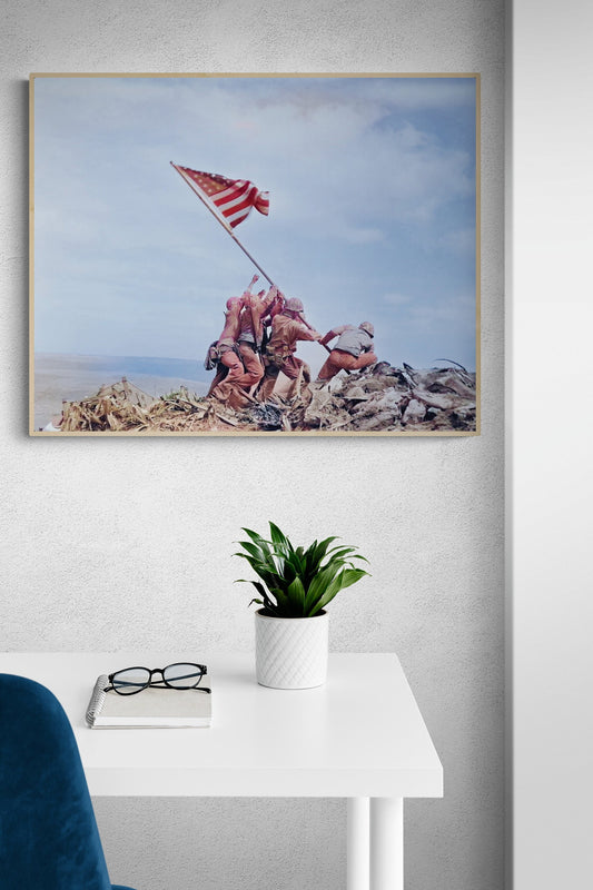 May include: A framed photograph of a black and white image of five soldiers raising a US flag on a hilltop. The soldiers are wearing military uniforms and are holding a flagpole with a US flag attached. The flag is waving in the wind. The soldiers are standing on a hilltop with a cloudy sky in the background.
