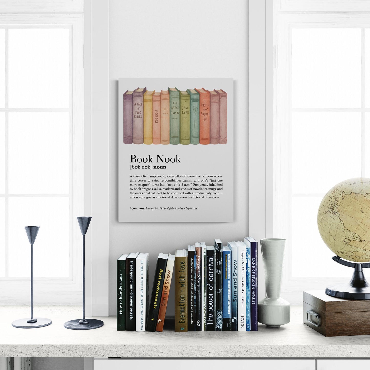 May include: A framed print titled 'Book Nook' with a definition and a row of colorful books. Below are several books on a shelf, including titles like 'How to handle & discover secrets', 'Bet restaurants', and 'Sun and Snow'. Two black candle holders are on the left.