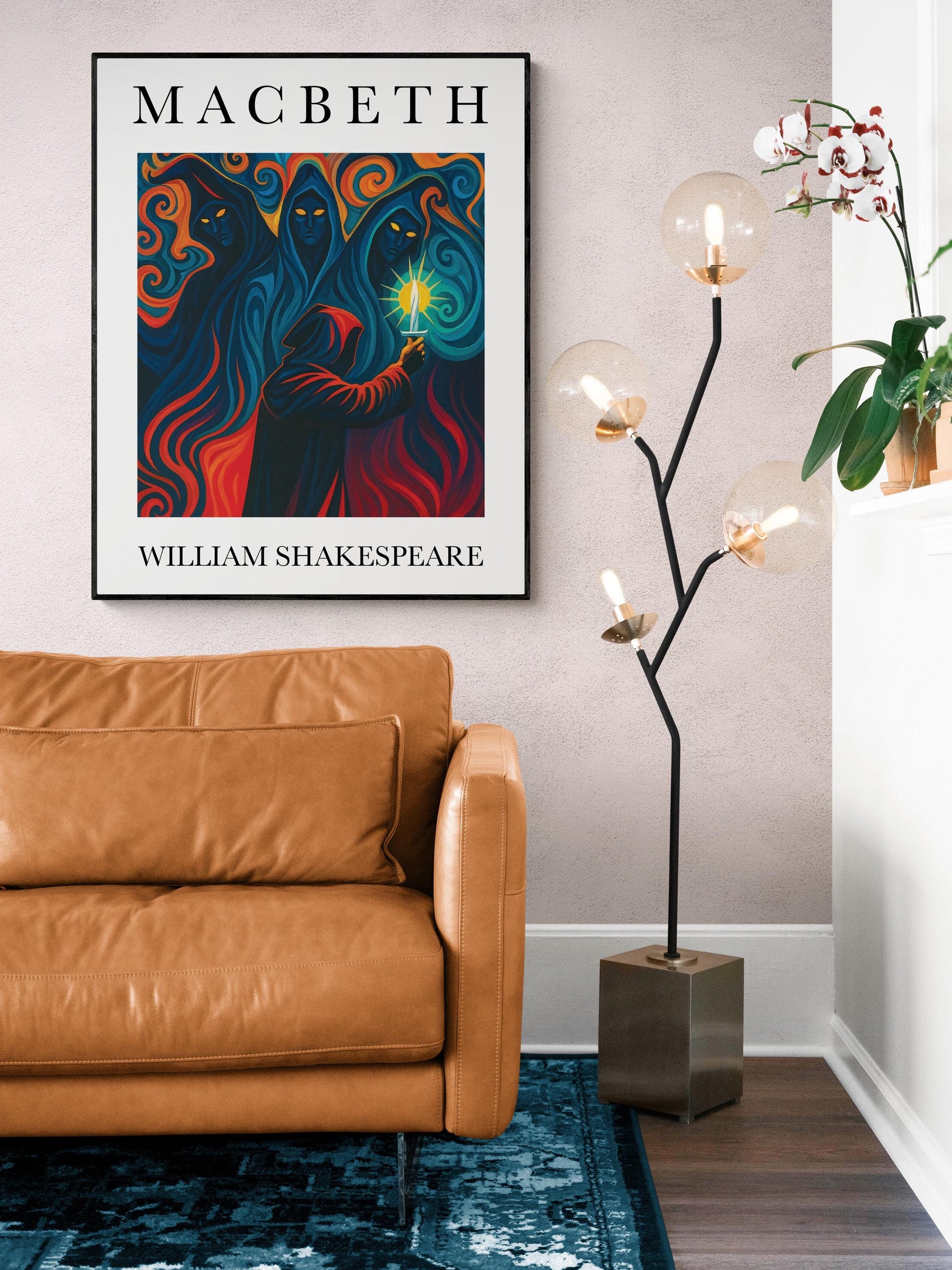 May include: A framed 'Macbeth' poster by William Shakespeare. The artwork features figures in dark robes with a central figure holding a glowing light. A brown leather couch with a matching pillow sits on a blue patterned rug. A modern floor lamp with globe lights and a square base is next to the couch.